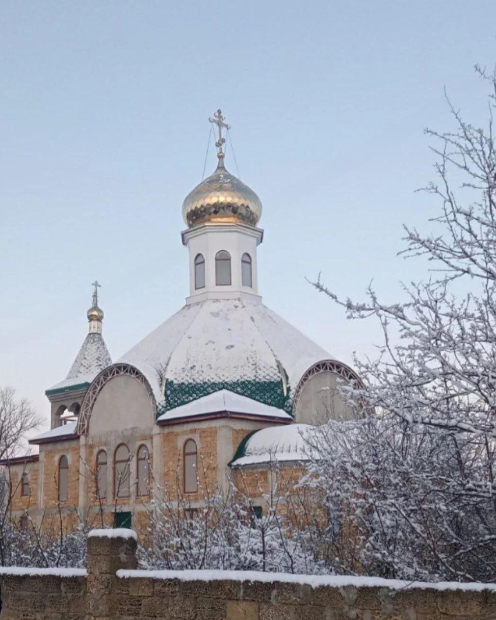 Фотография строительства храма — рабочие, леса и купол на фоне неба
